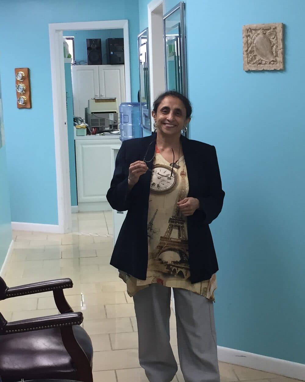Dr. Prabha Raju smiling in the hallway of Tender Dental Care in Burton, Michigan
